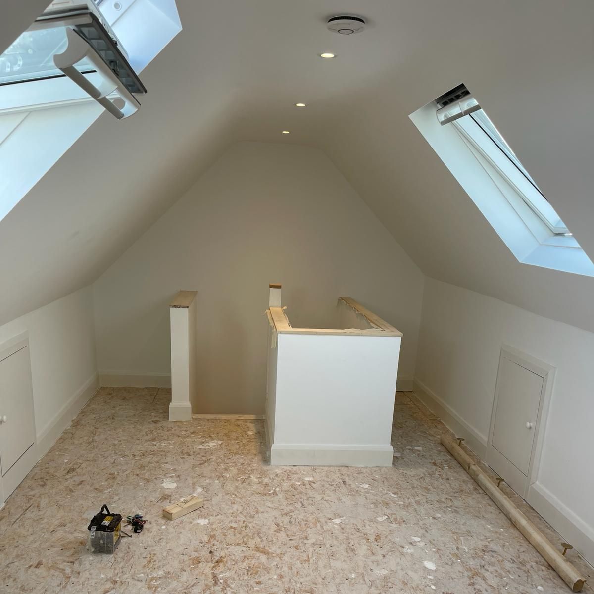 A room with a staircase and a skylight in the ceiling