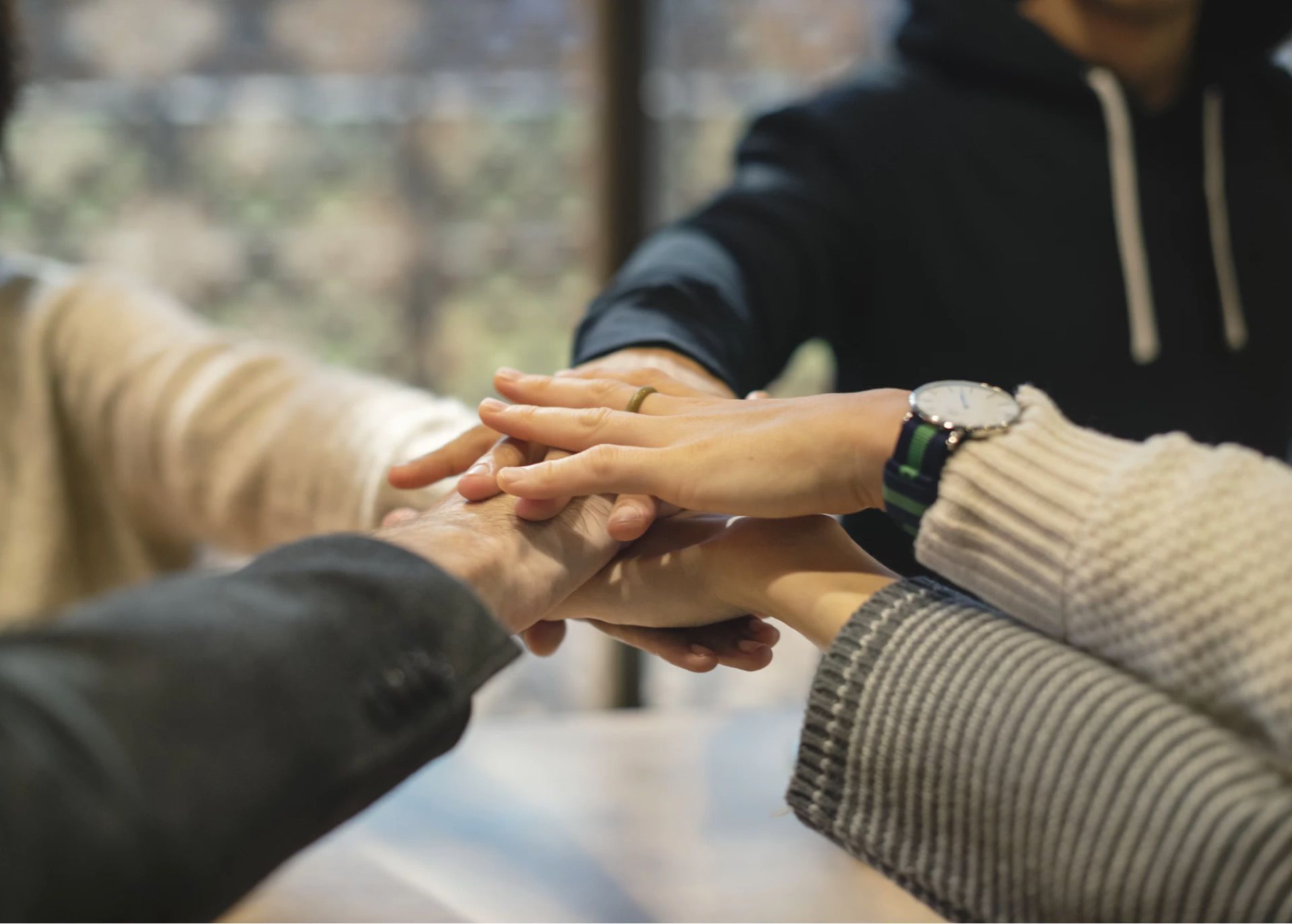 A group of people are putting their hands together.