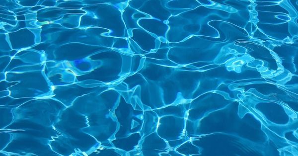 A close up of the water in a swimming pool.