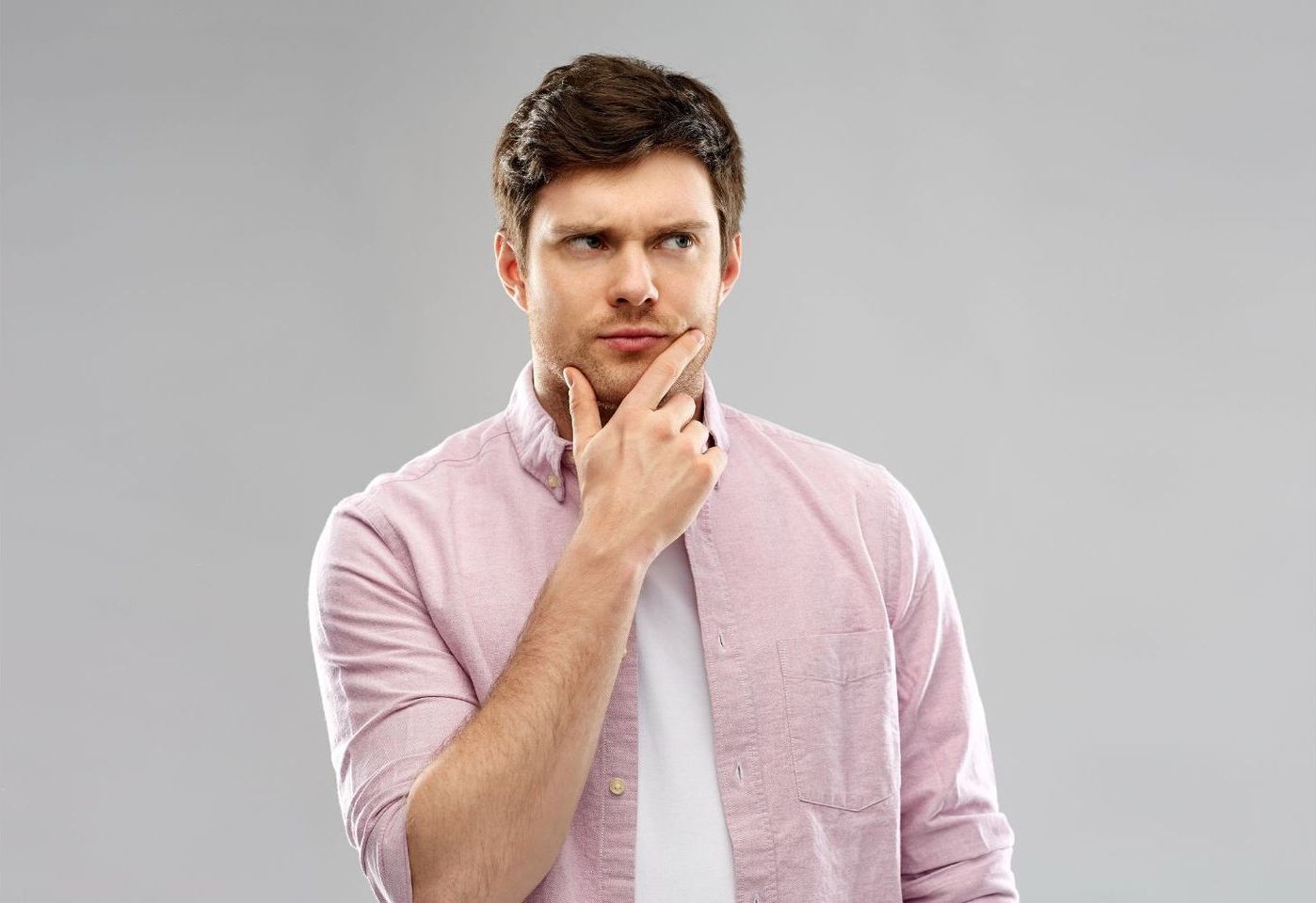 Man in pink shirt thinking to make a desicion
