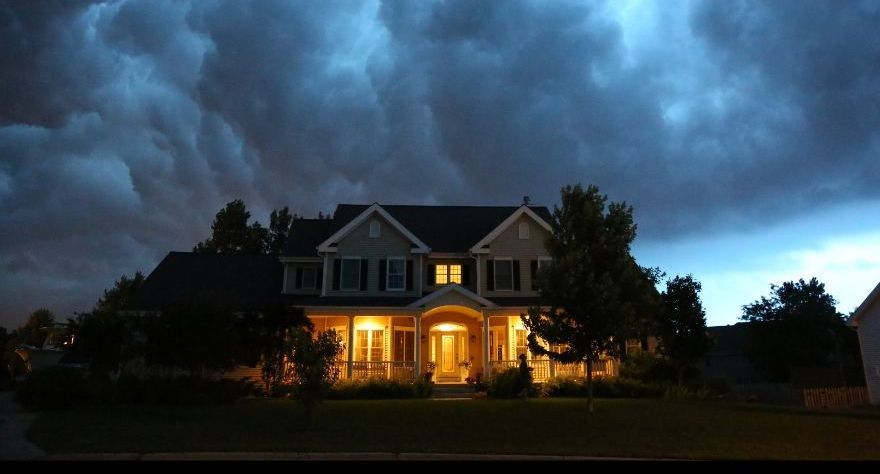 Spooky dark halloween house under gray cloudy skies.