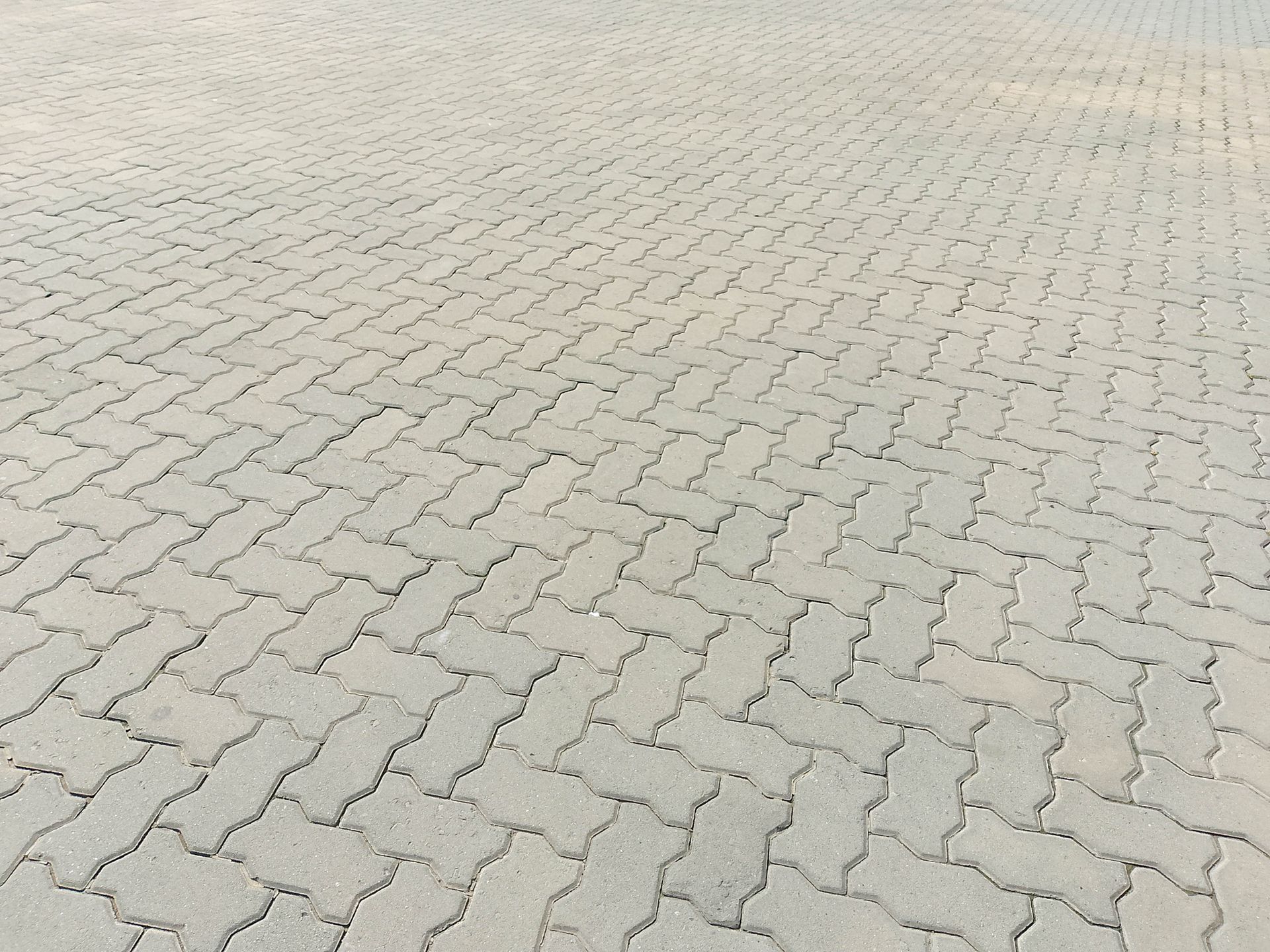 Cavi arancioni in un cantiere stradale, con coni stradali e un'auto sullo sfondo.