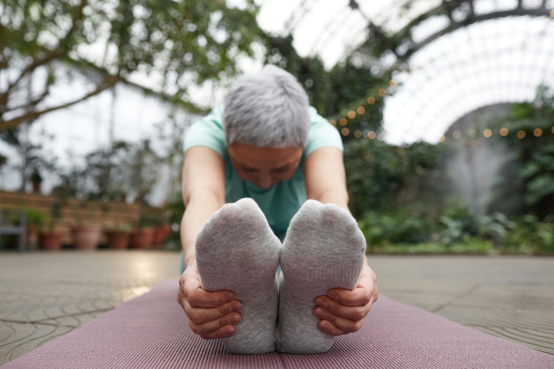 Woman stretches on a mat reaching for toes.