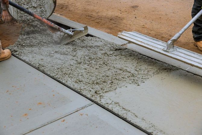 a person pouring concrete for a concrete slab