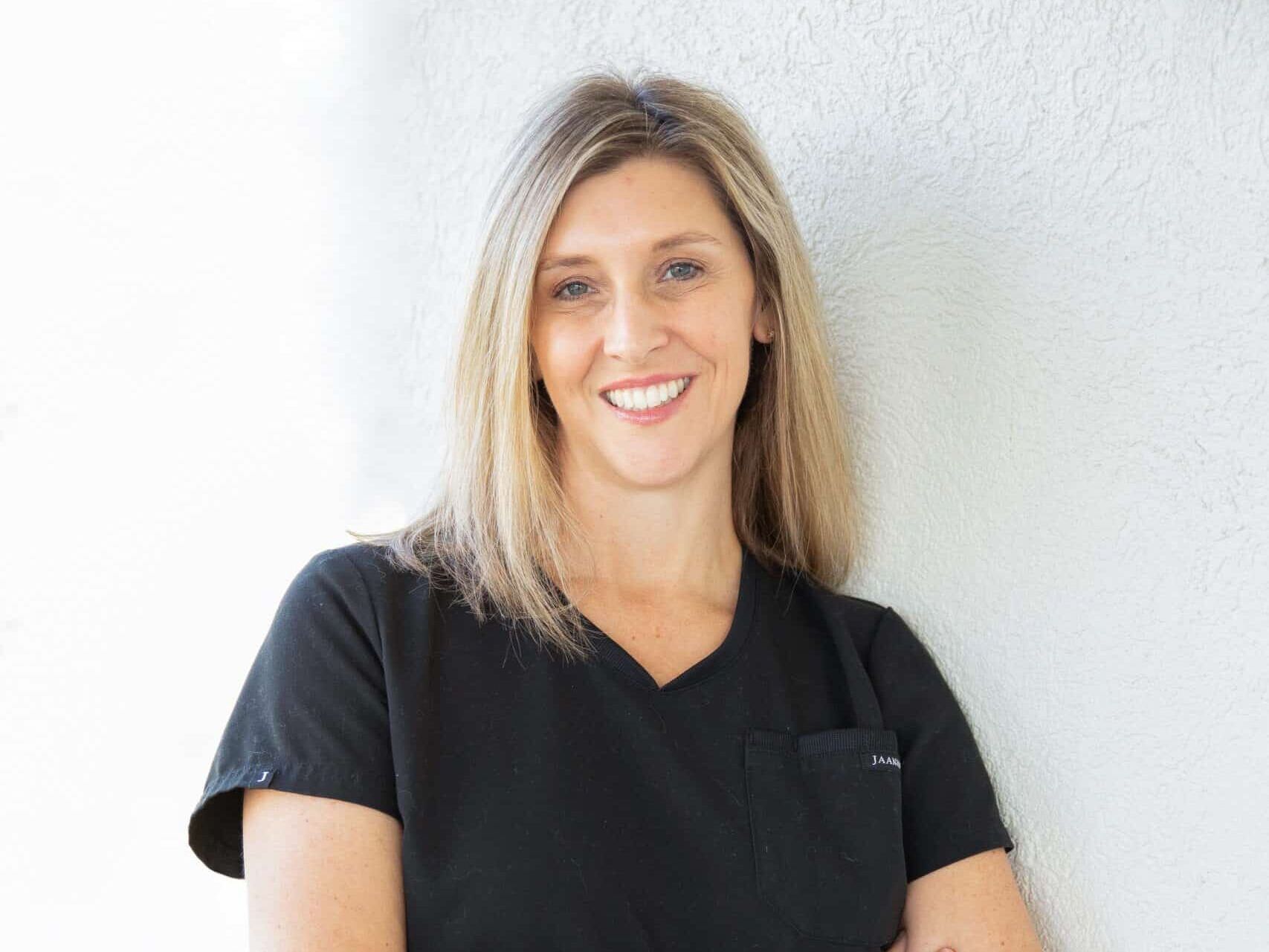 A woman wearing glasses and a black jacket with the word boost on it 