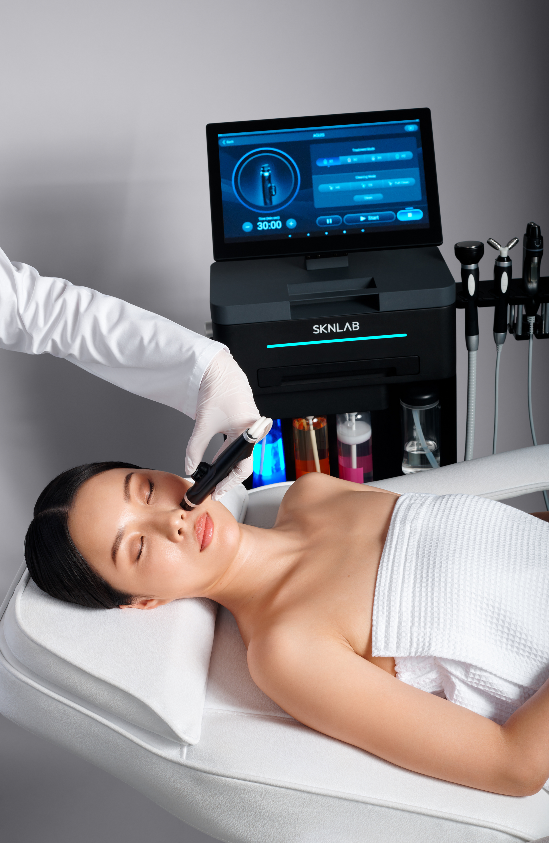 A woman is laying on a bed getting a facial treatment.