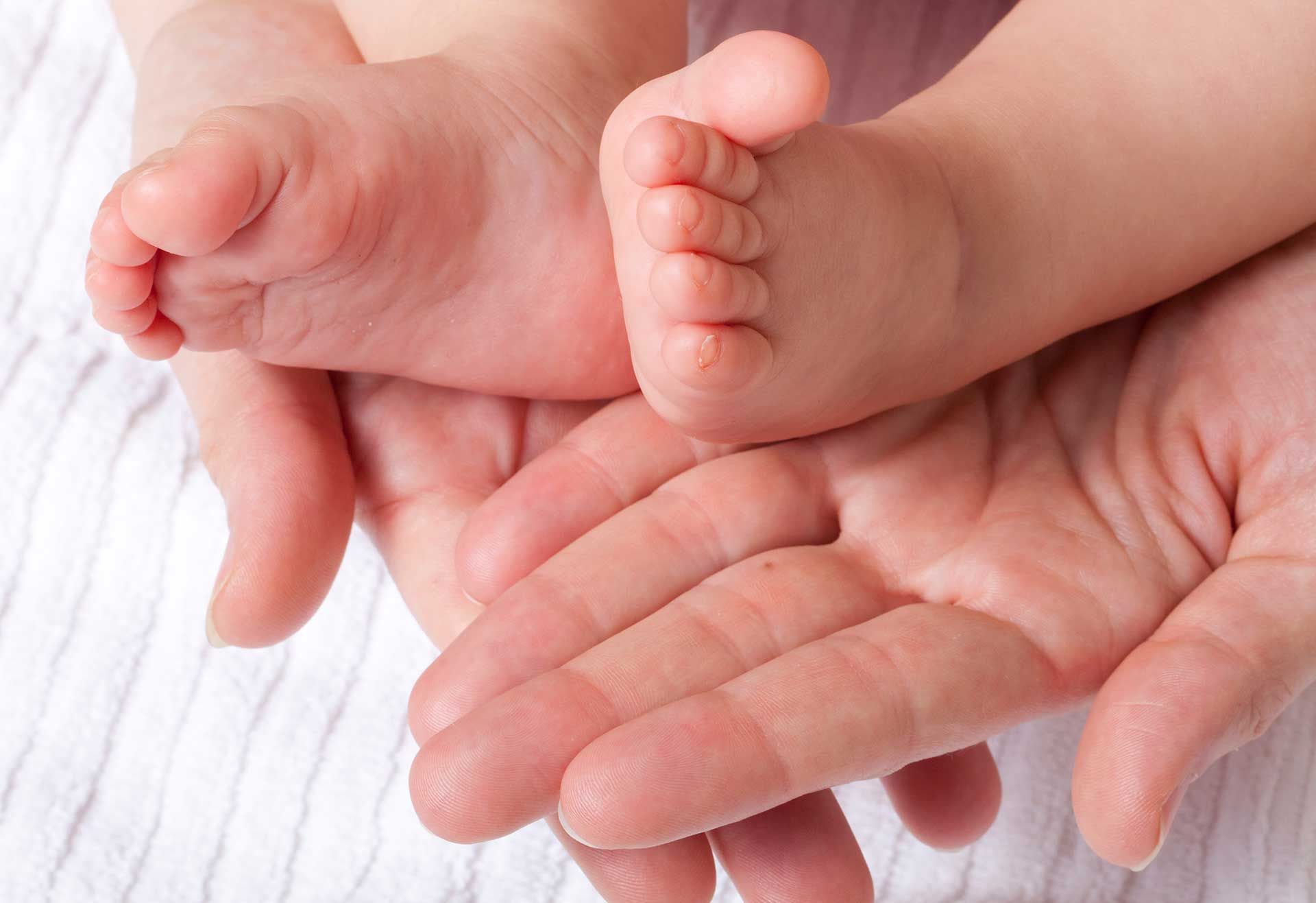 Mother's hands and baby's feet