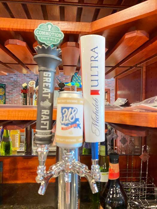 Three beer taps: Great Raft, 318, and Michelob Ultra at a bar, brown interior.