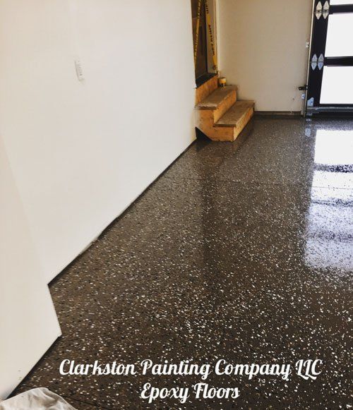 An empty room with stairs and the words clarkston painting company llc on the bottom