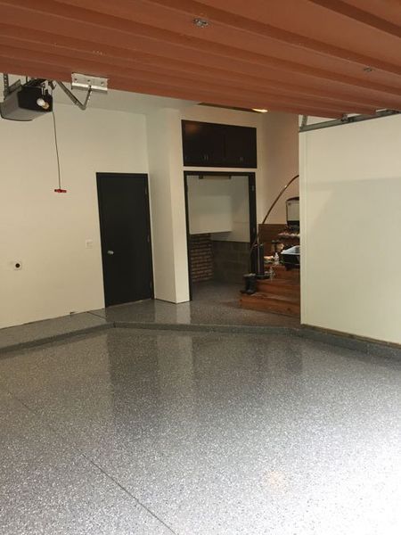 An empty garage with a red ceiling and a black door