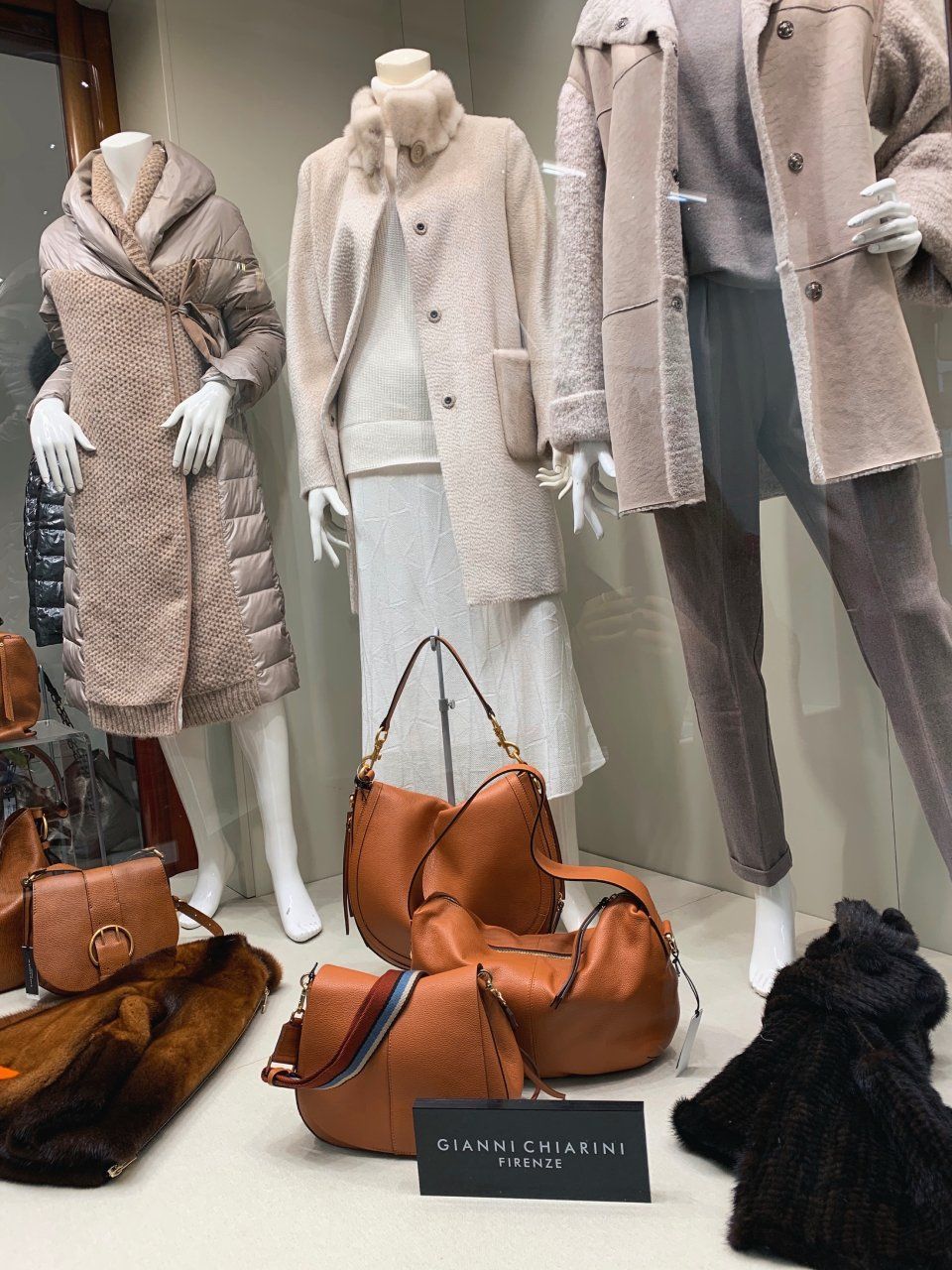 Una donna con un vestito arancione è in piedi su una strada cittadina.
