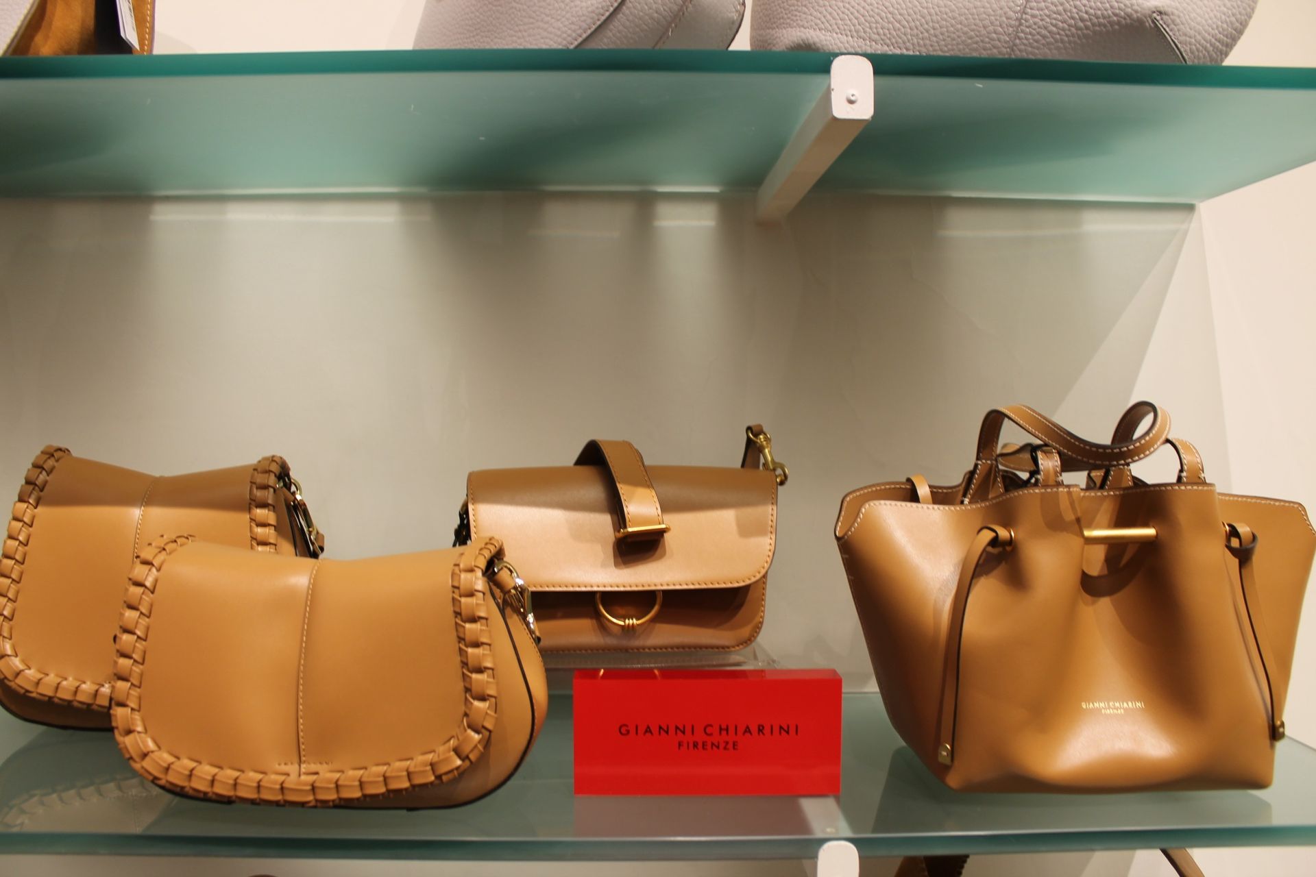 Una donna con una camicia bianca tiene in mano una borsa nera