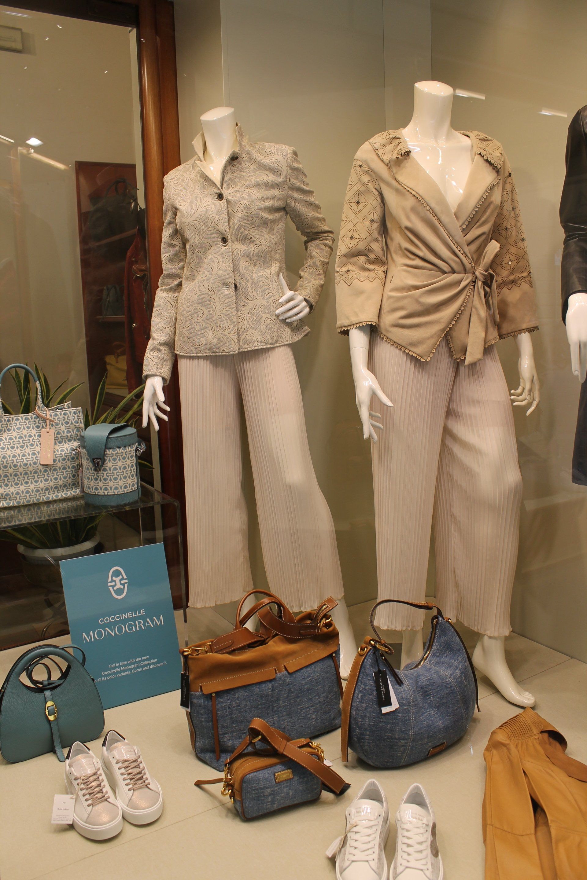 Un'esposizione di vestiti e borse nella vetrina di un negozio.