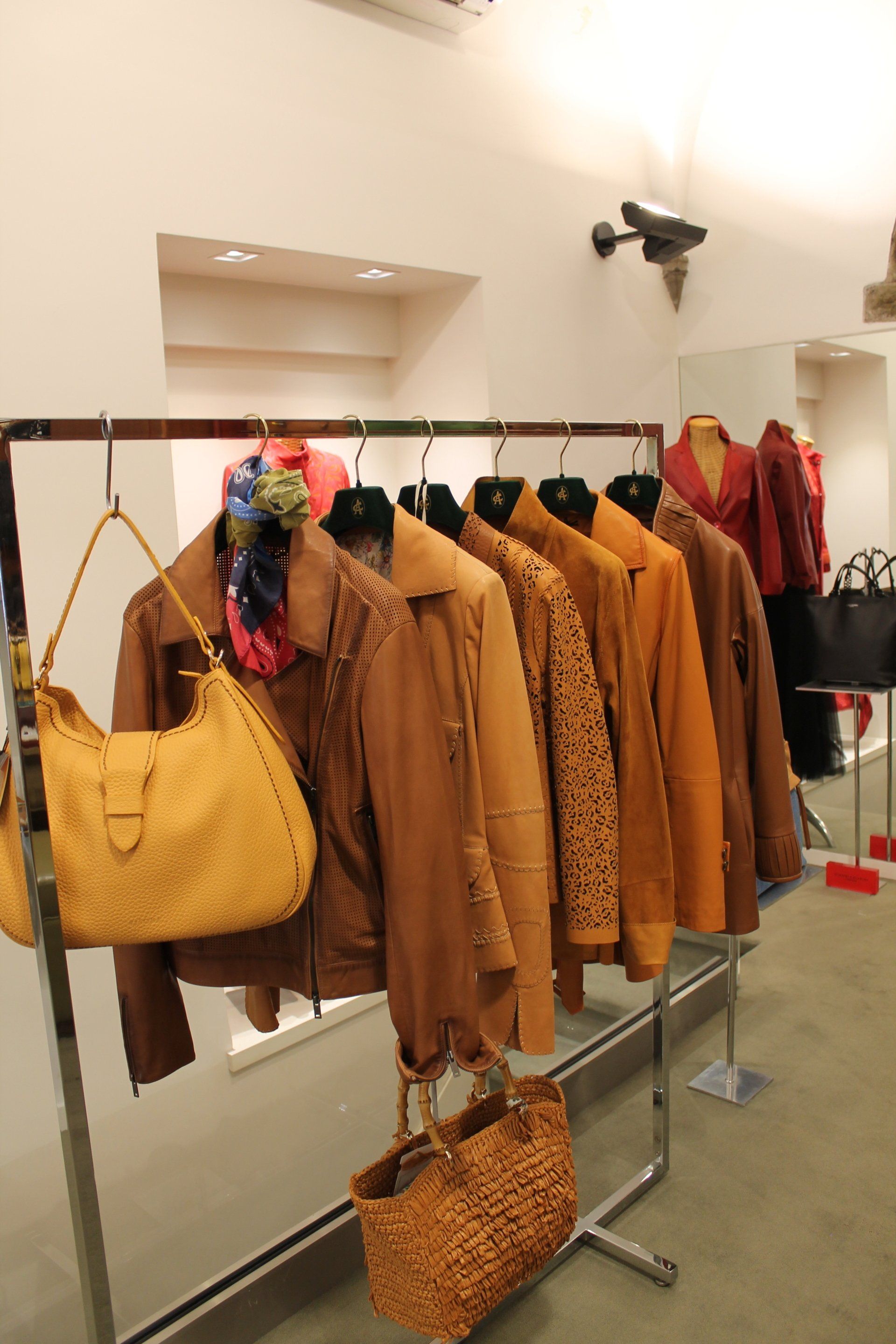 Una fila di giacche di pelle marrone appese a un attaccapanni