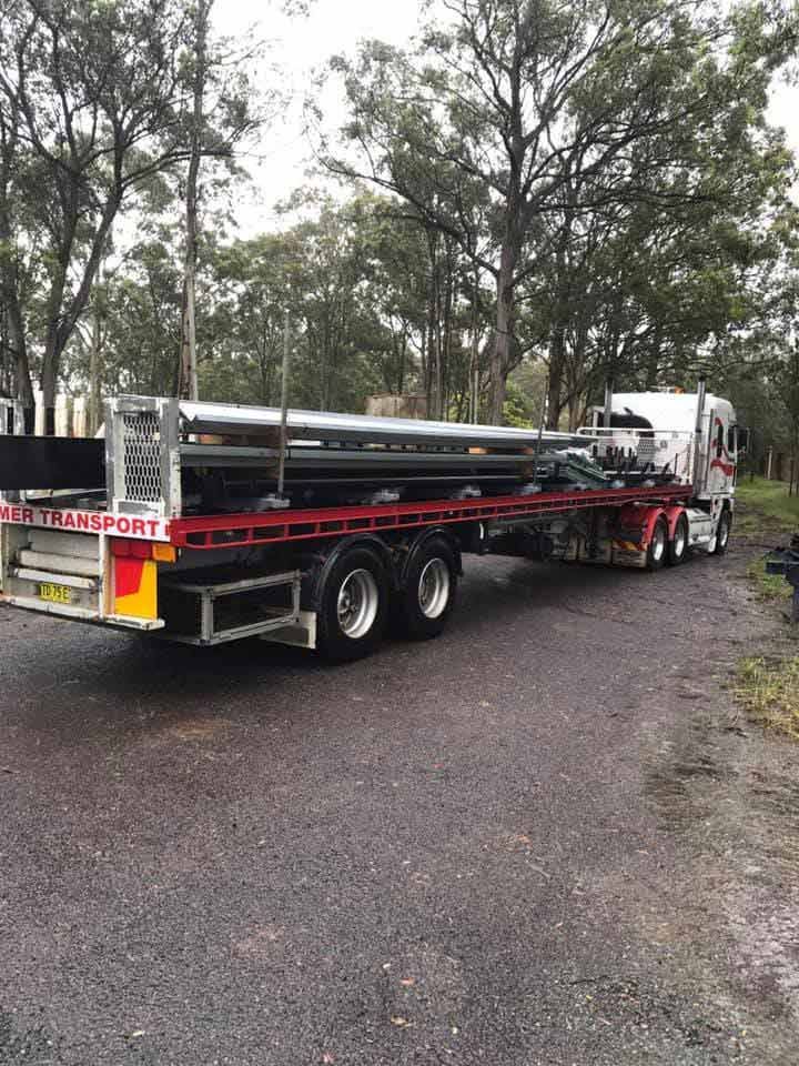 A semi truck is carrying large pieces of metal steel on a trailer — Primmer Steel In Nabiac, NSW