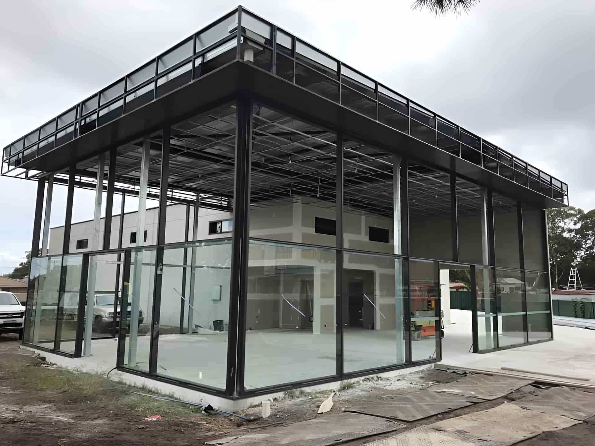 A Large Building With A Lot Of Windows Is Being Built — Primmer Steel In Taree, NSW