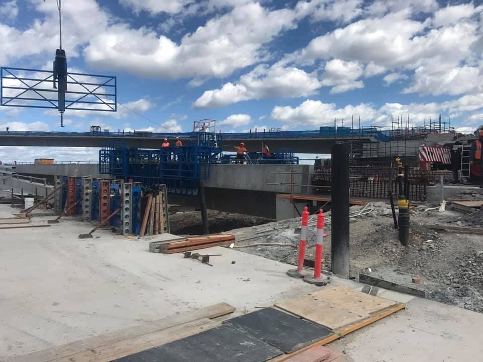 A Construction Site With A Crane Lifting A Bridge Over A Body Of Water — Primmer Steel In Nabiac, NSW
