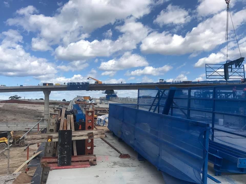 A Construction Site With A Blue Fence And A Crane — Primmer Steel In Nabiac, NSW