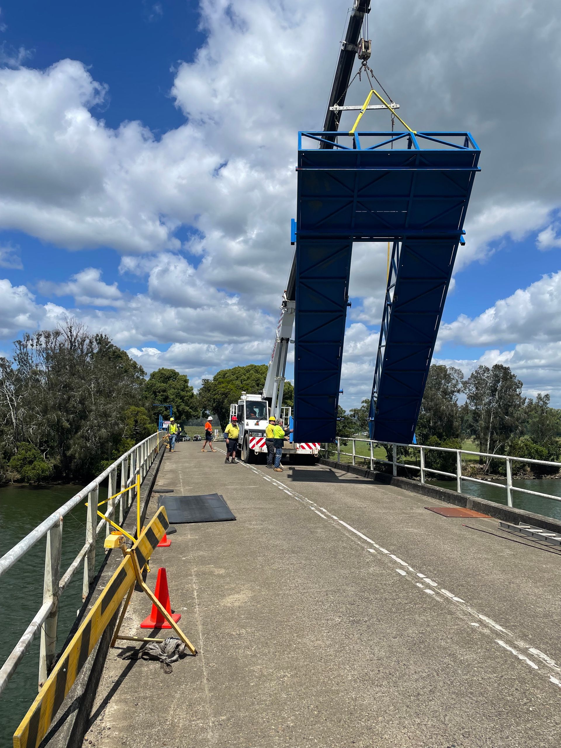 A Man On A Ladder Is Working On The Roof Of A Building — Primmer Steel In Forster, NSW
