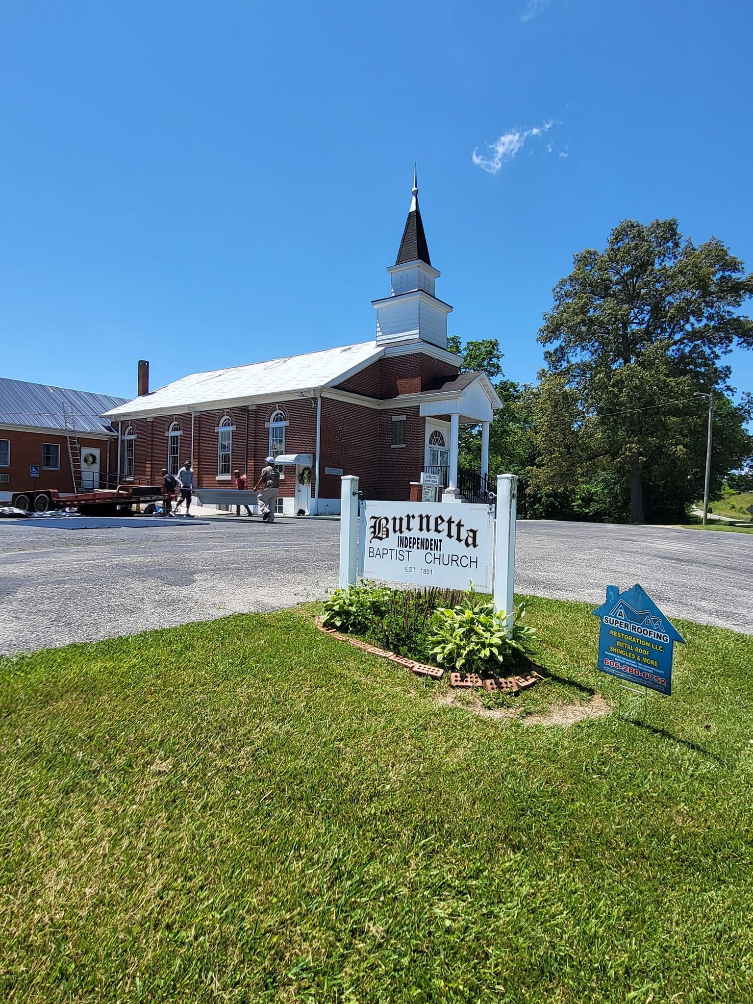 White church with steeple, sign reading