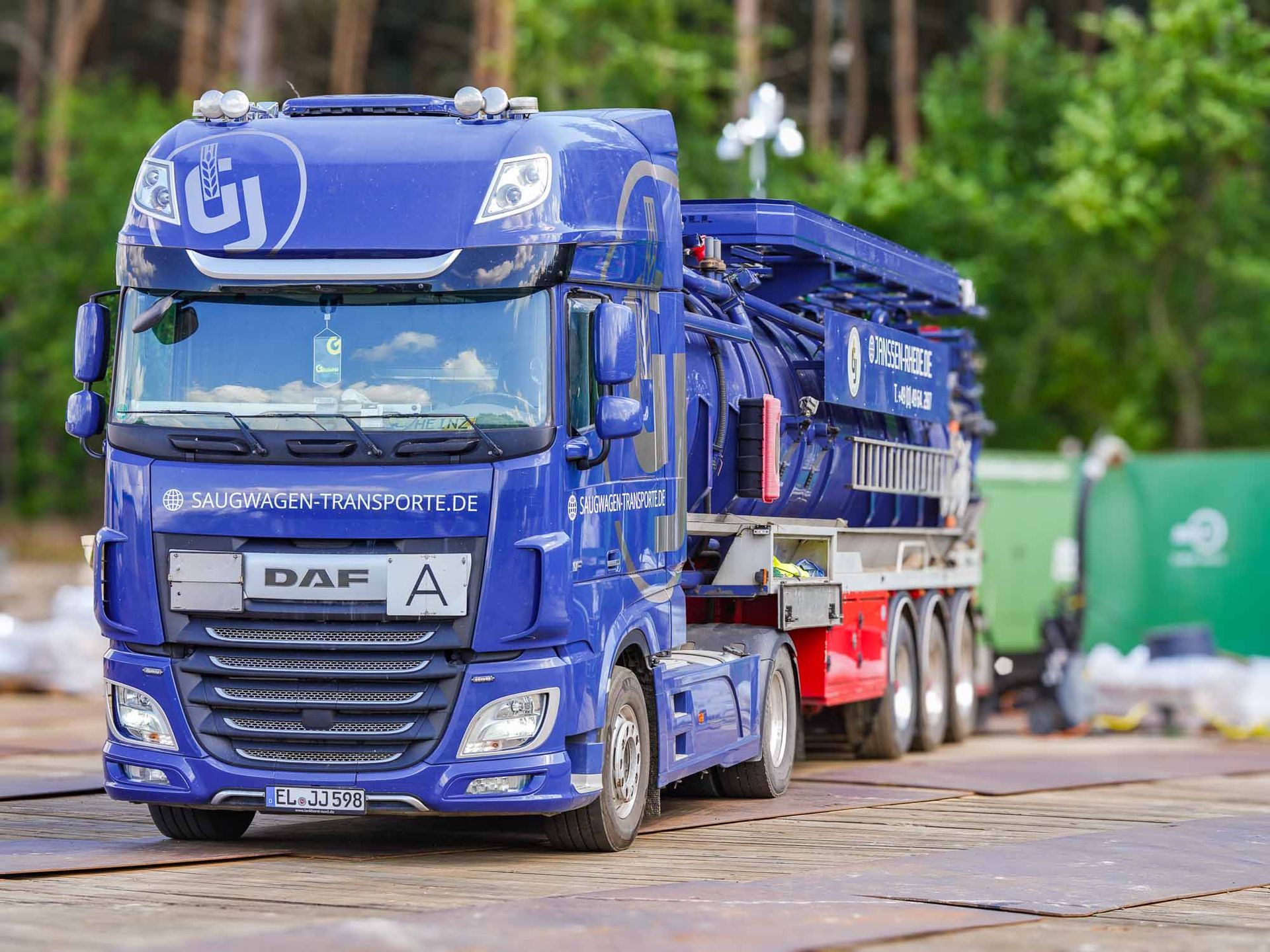 Ein blauer Lastwagen steht auf einer Metalloberfläche auf einem Parkplatz.