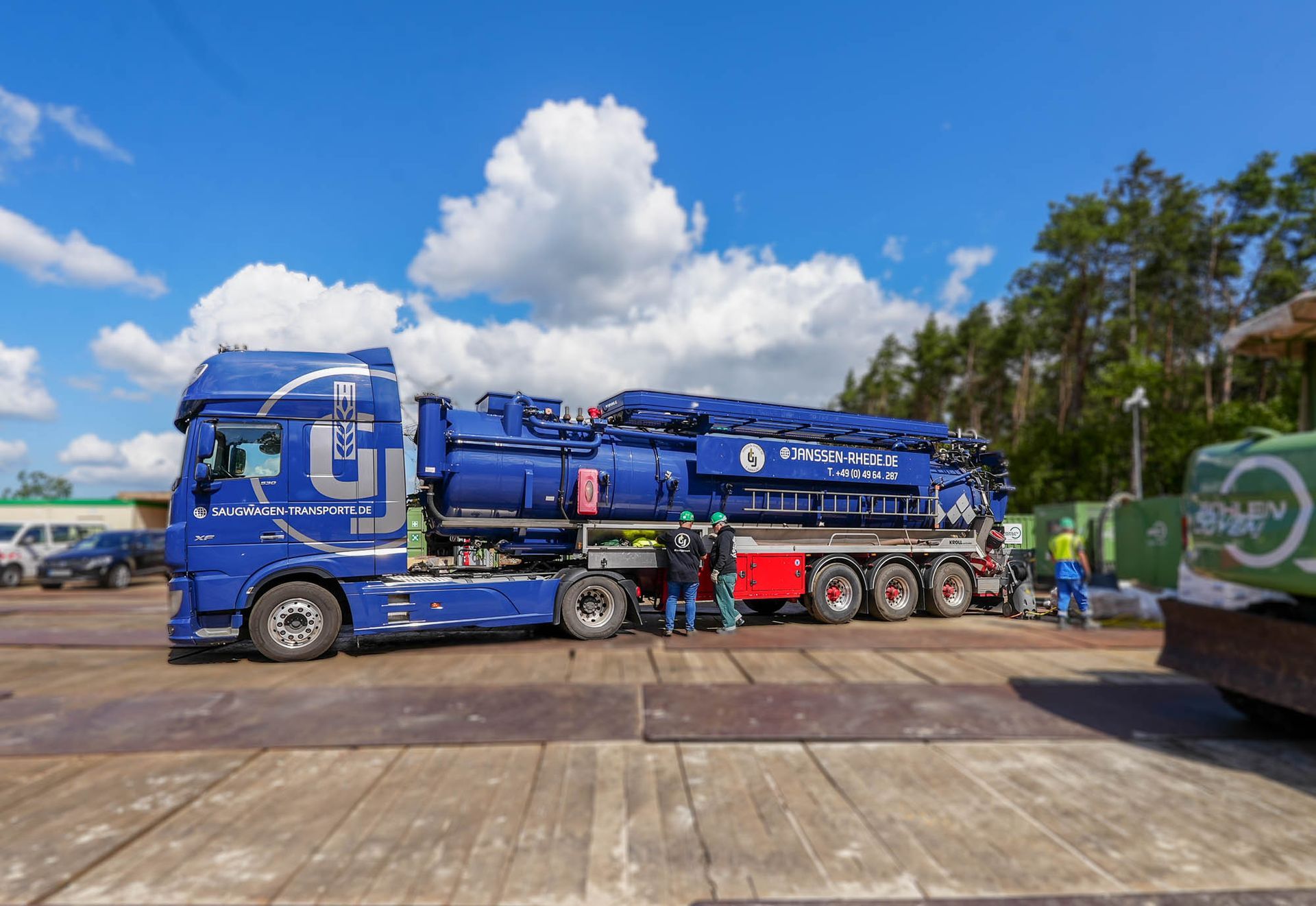 Auf einem Parkplatz steht ein blauer Saugwagen.