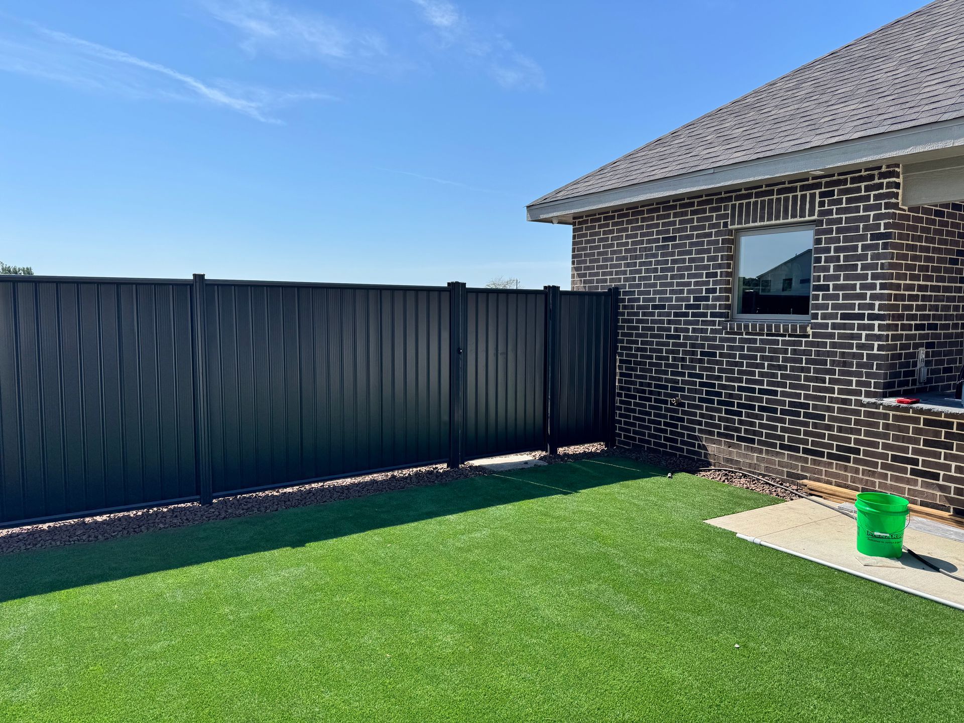 Wooden fence in backyard, chain-link fence on top.
