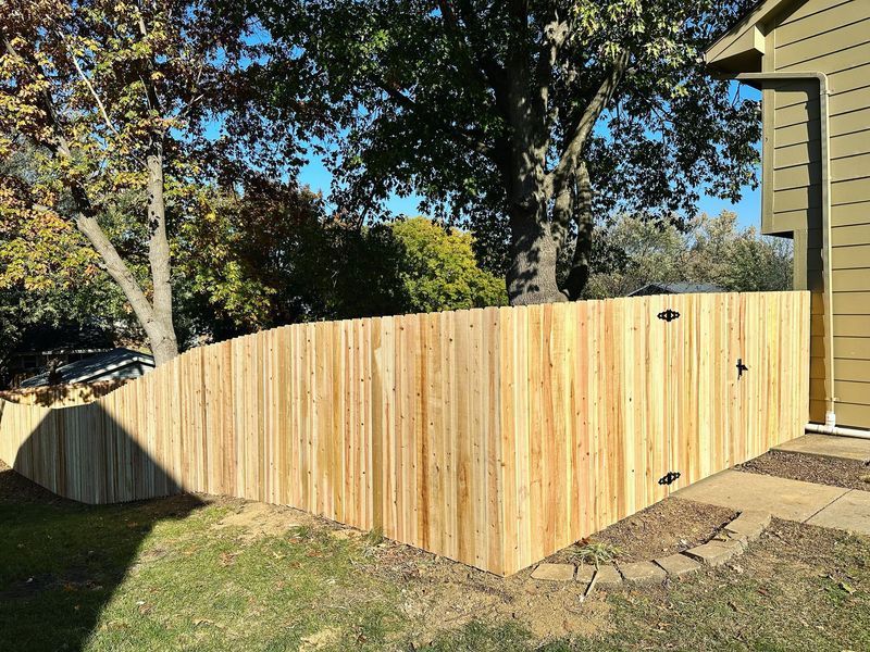 Wooden fence in a yard, curved design. 