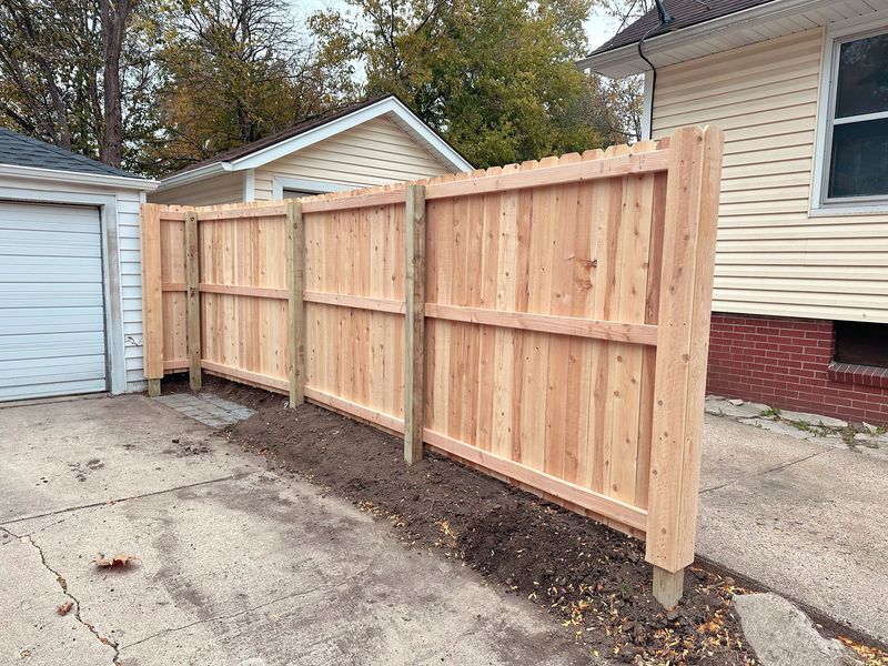 New wooden fence alongside a garage and house.