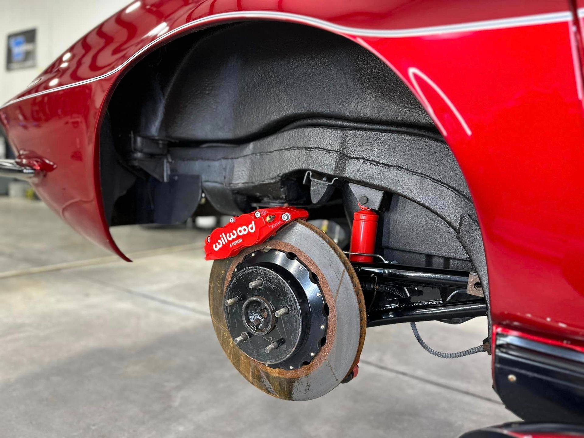 A close up of a red car with a brake on it.