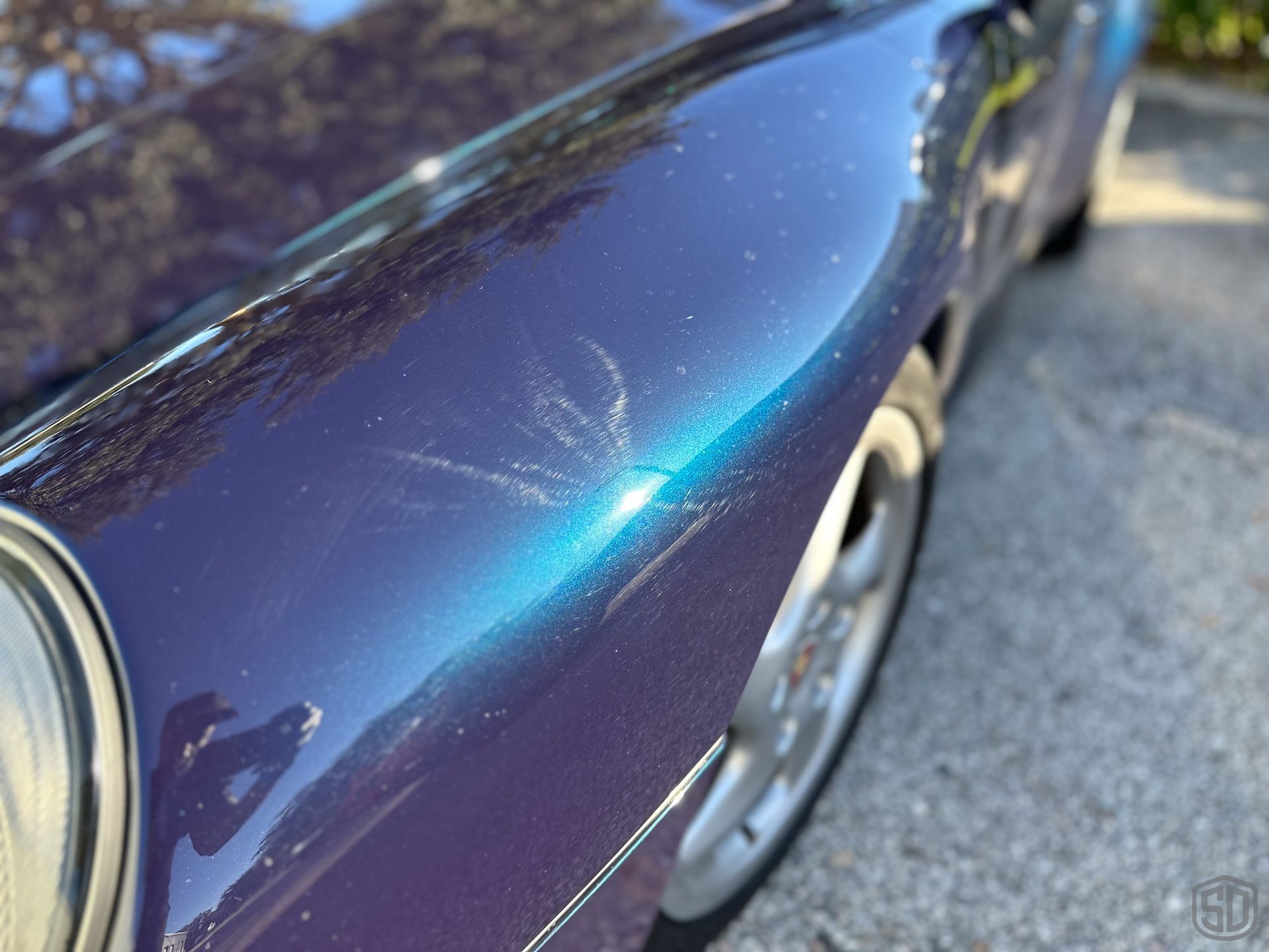 A purple car is parked on the side of the road
