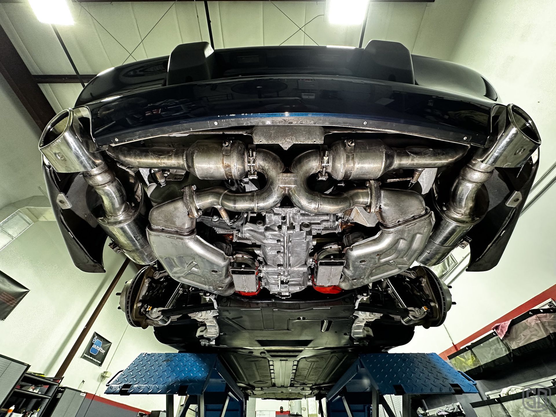 A car is sitting on a lift in a garage.
