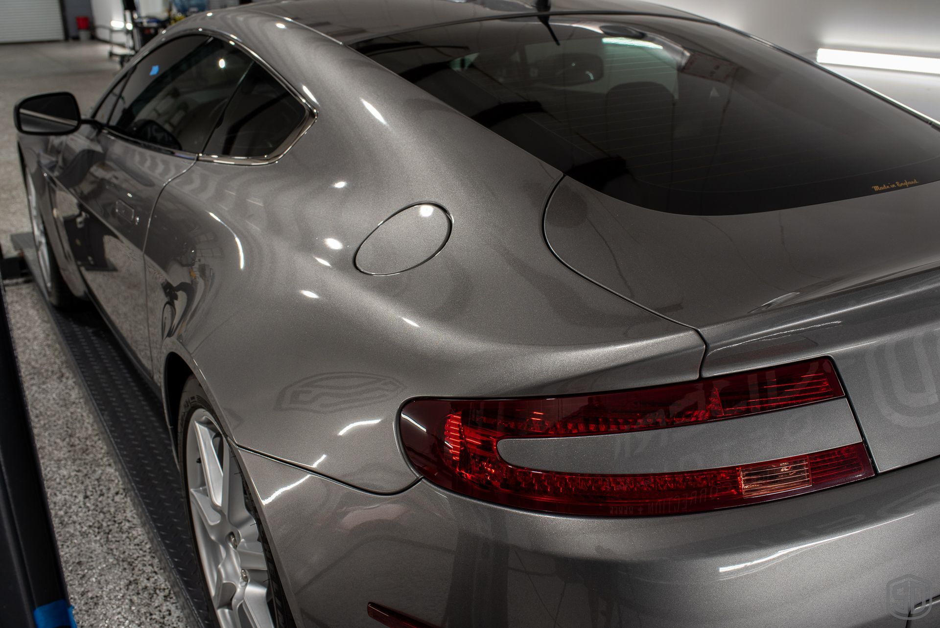 A silver sports car is parked in a garage.