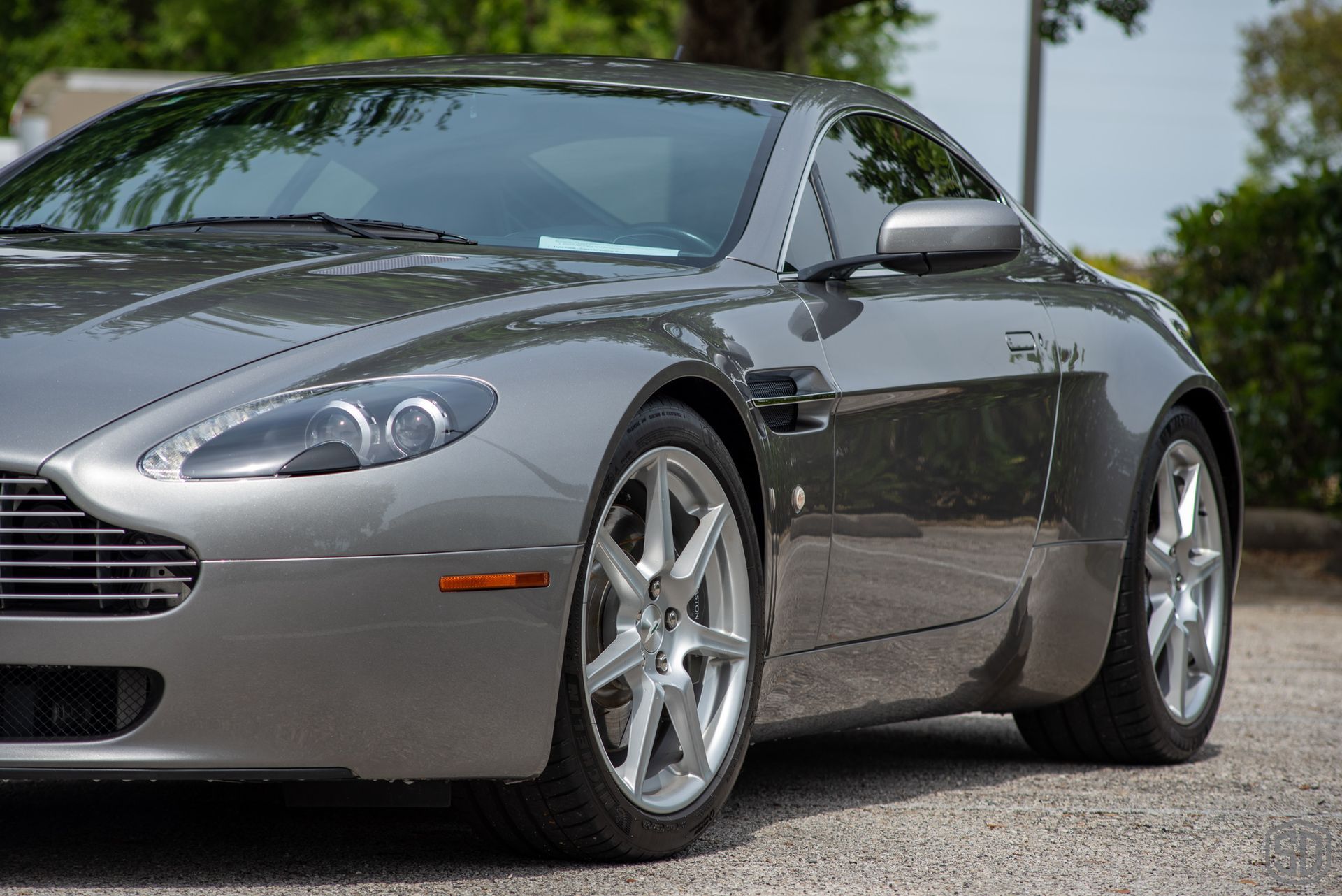 A gray sports car is parked on the side of the road.