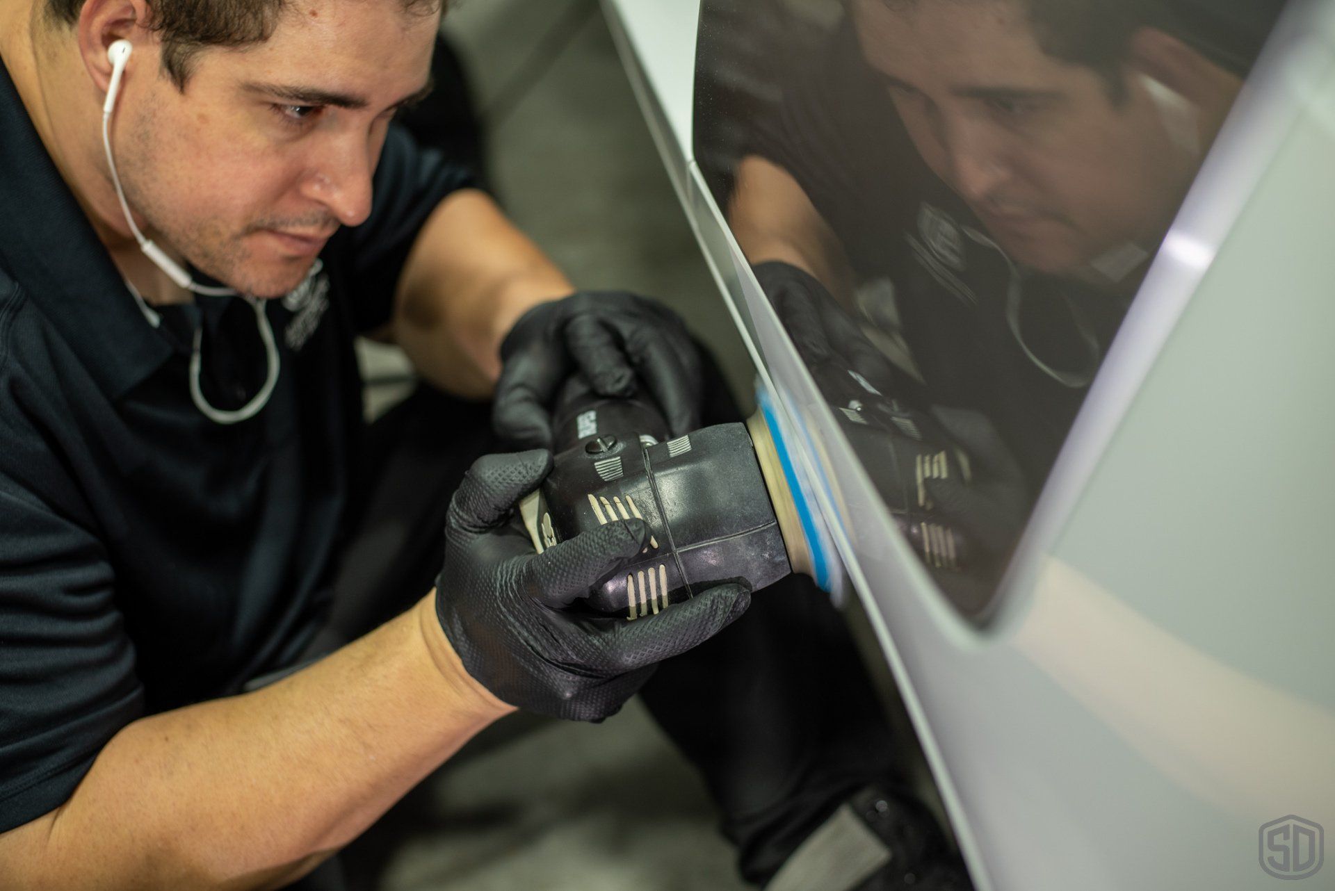 A man is polishing a car with a machine.