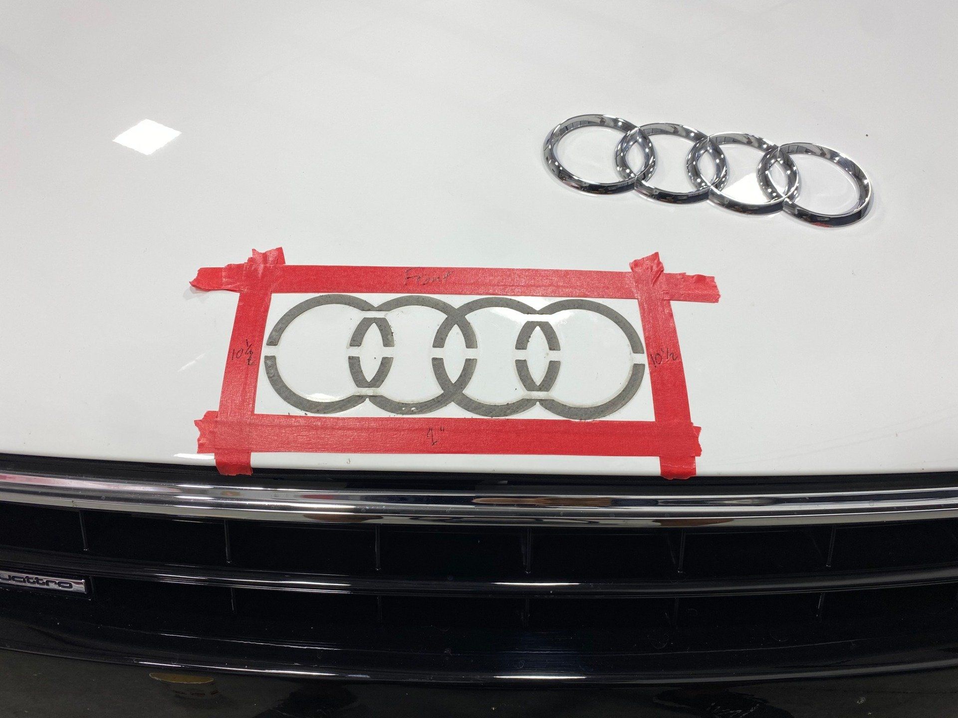 An audi logo is taped to the hood of a car