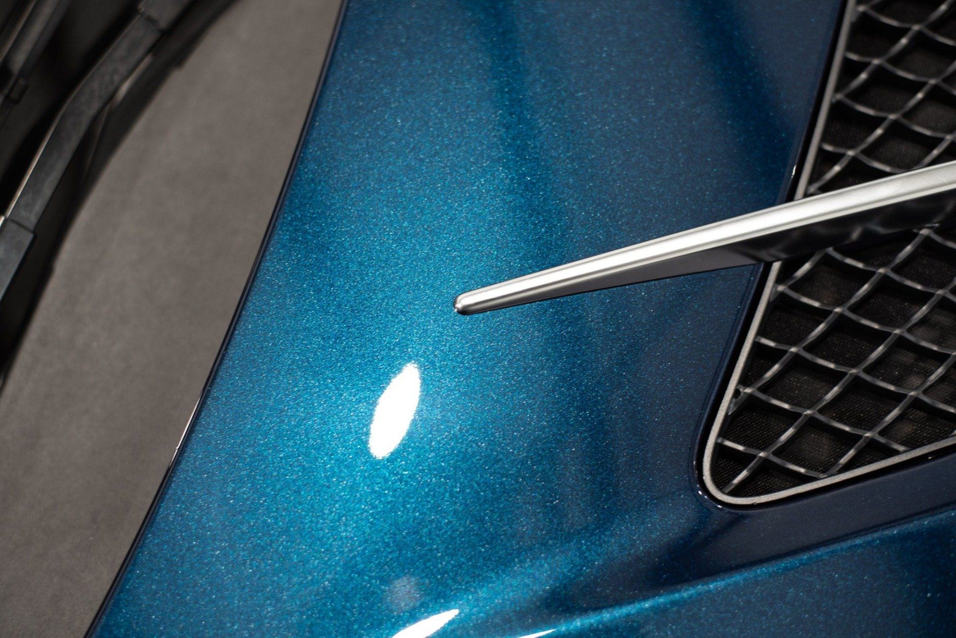 A close up of the hood of a blue car