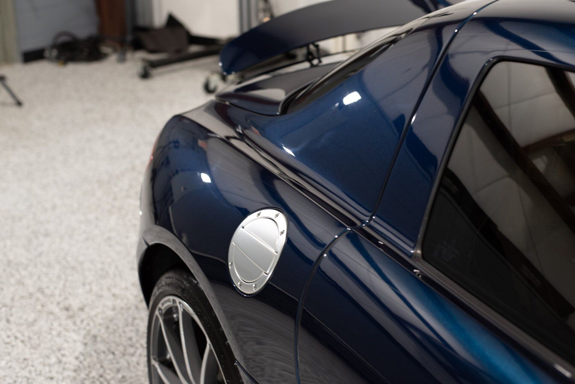 A blue sports car is parked in a garage