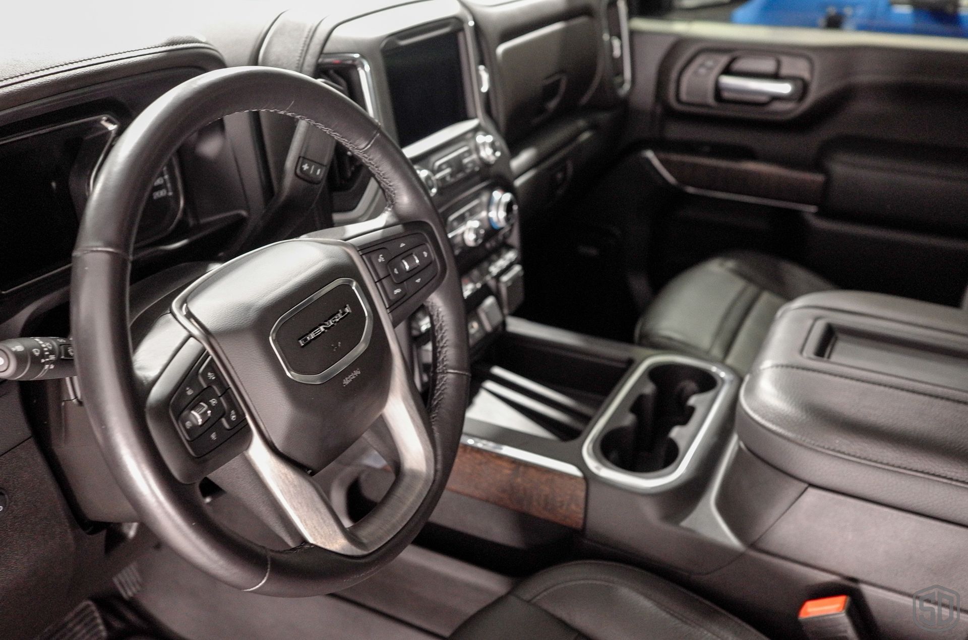 The interior of a gmc truck with a steering wheel and a center console.