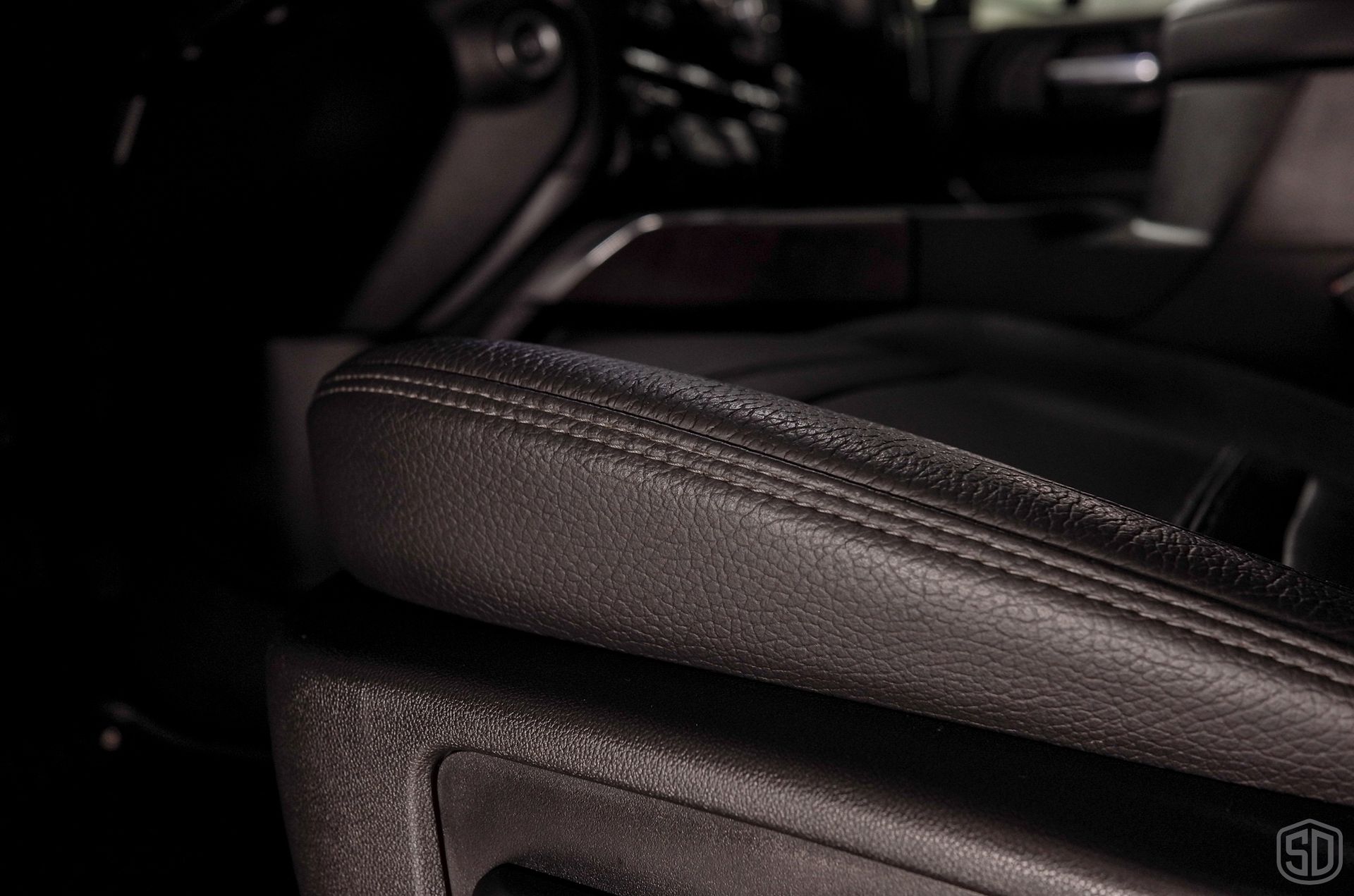 A close up of a leather arm rest in a car.