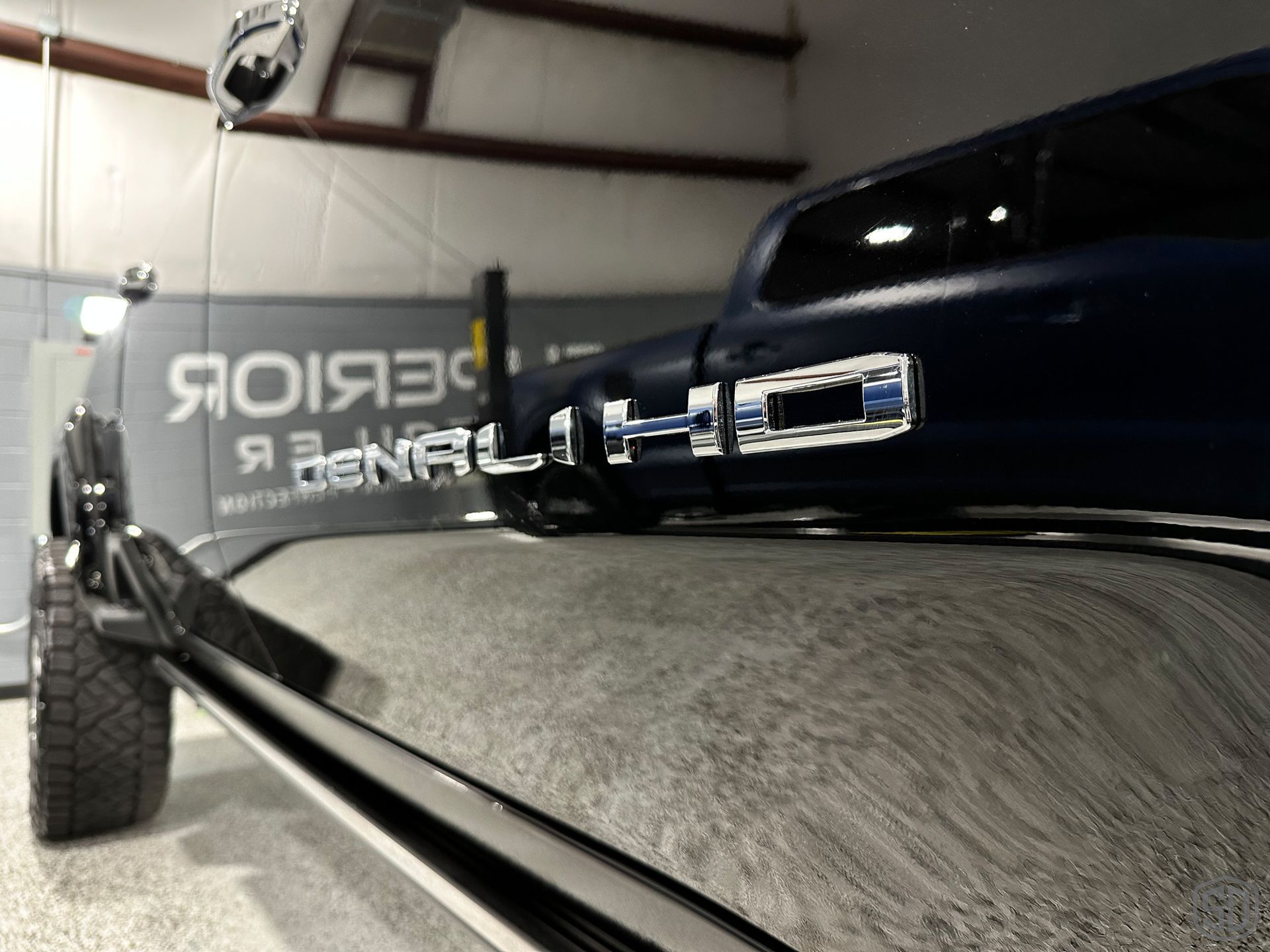 A blue truck with the word hd on the back is parked in a garage