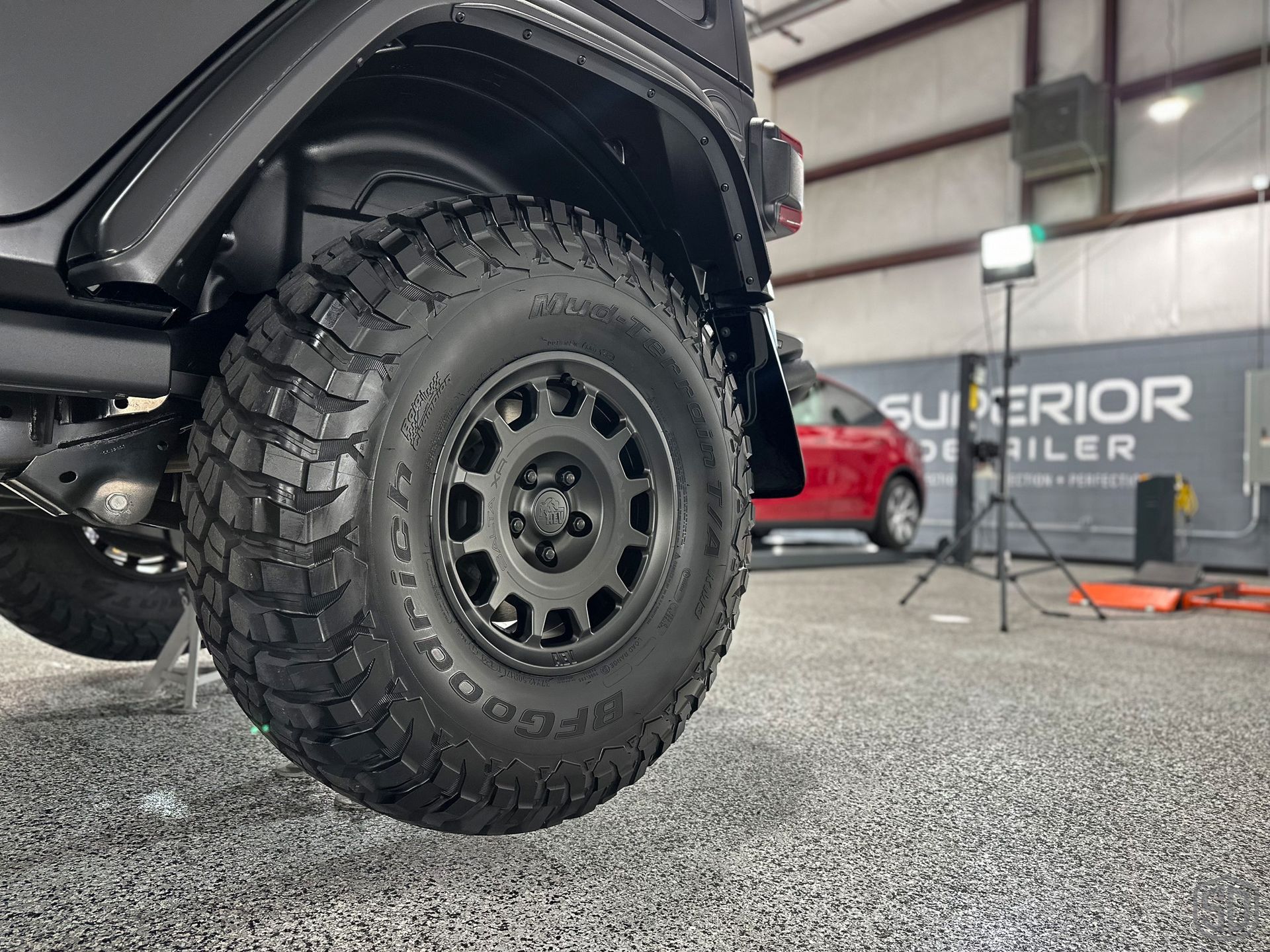 A close up of a tire on a jeep in a garage