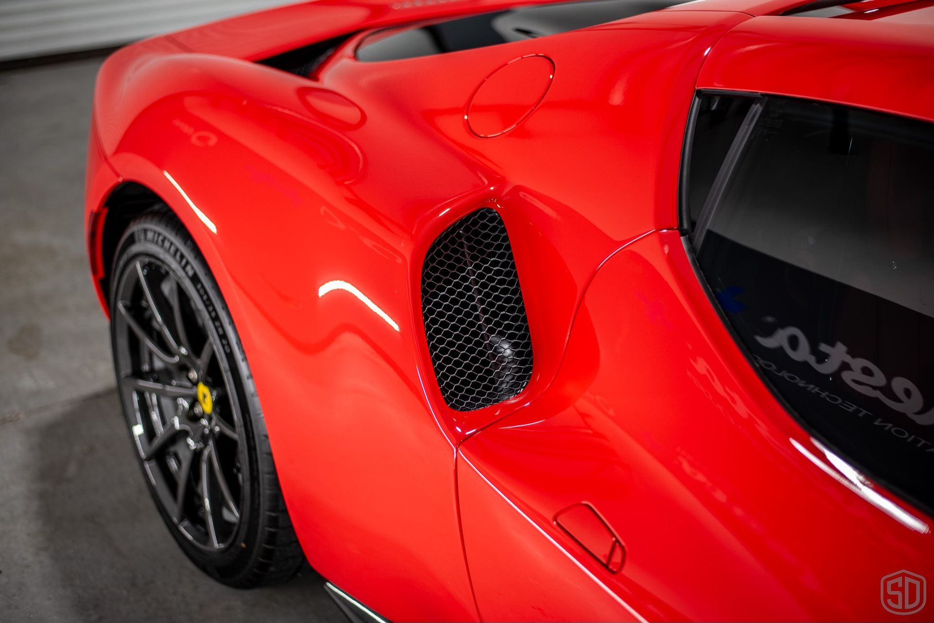 A red sports car is parked in a garage.