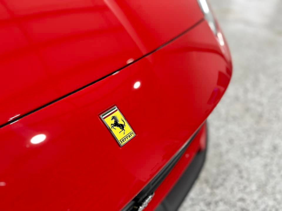 A red ferrari is parked in a garage