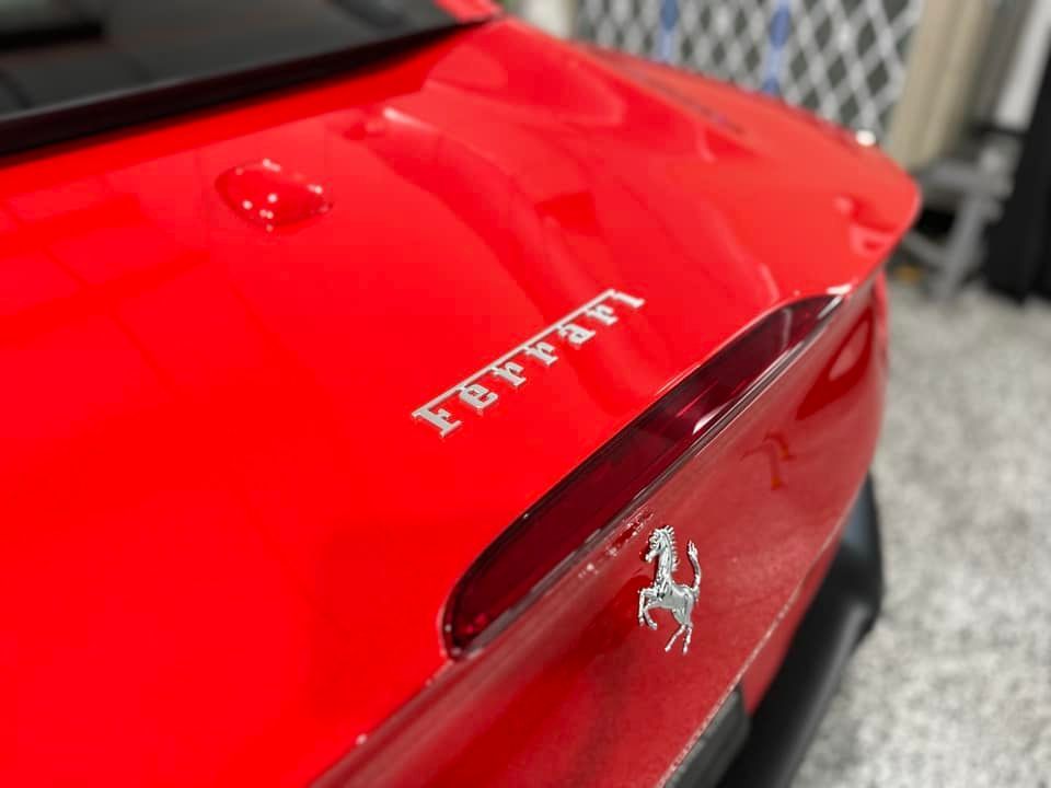 A red ferrari car is parked in a garage.