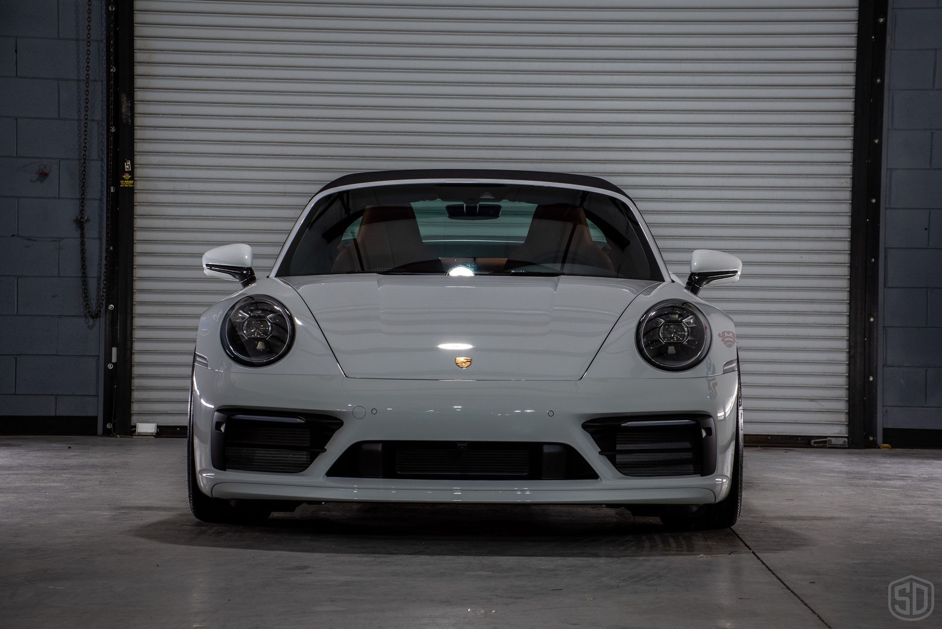 A white car is parked in front of a wall that says modesta plus creation technology
