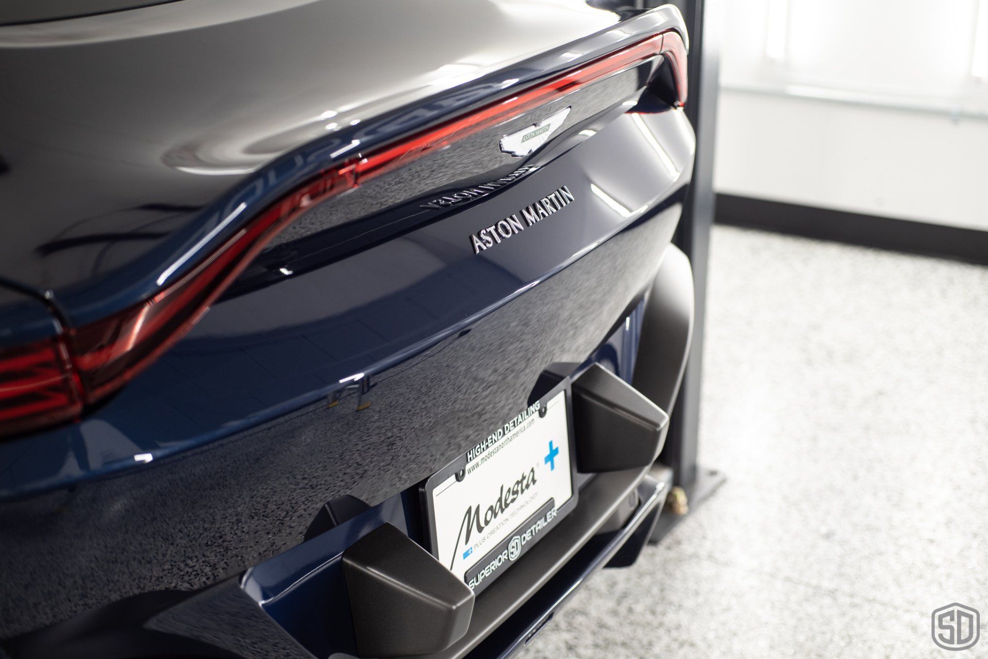 A blue aston martin car is parked in a garage