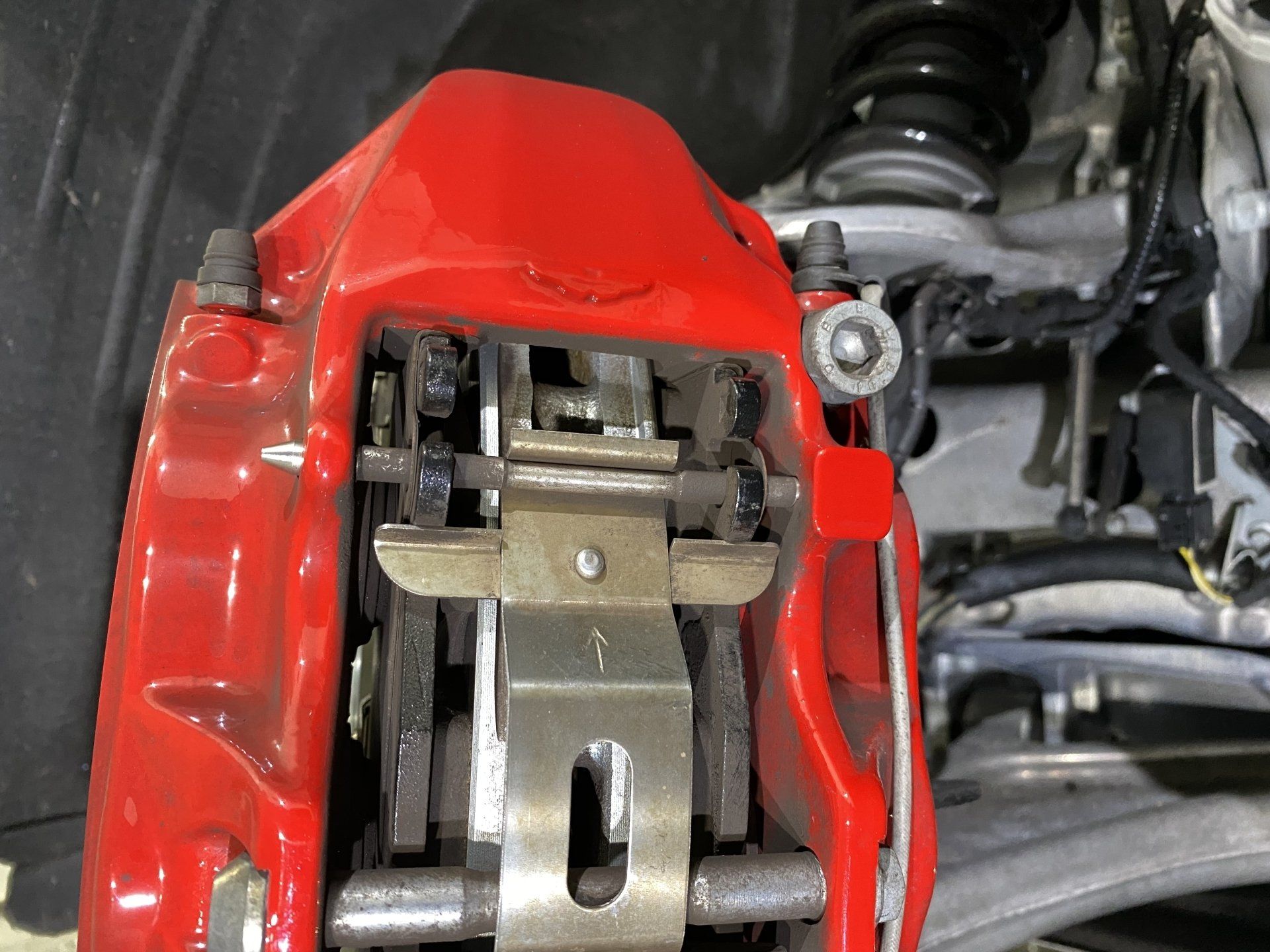 A close up of a red brake caliper on a car