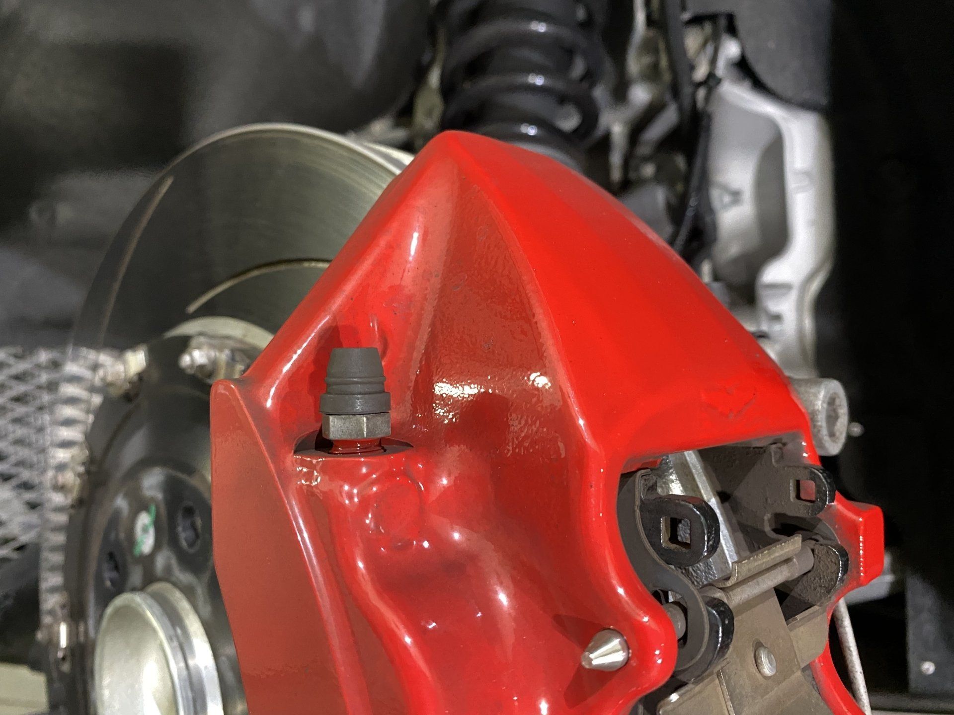 A close up of a red brake caliper on a car