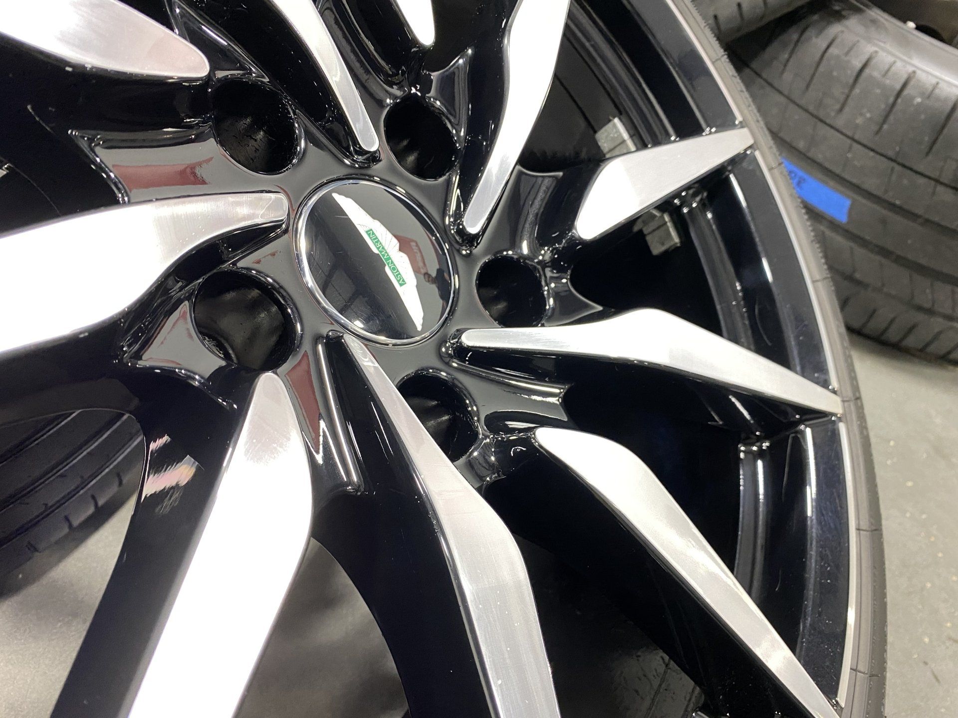 A close up of a wheel with a tire in the background